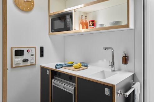 kleine Küche mit Mikrowelle, Kühlschrank und Waschbecken