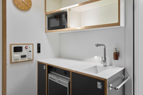 kleine Küche mit Mikrowelle, Waschbecken und Kühlschrank