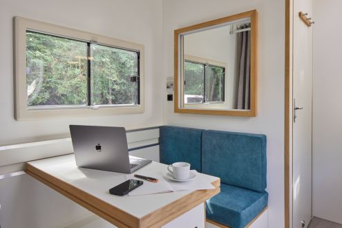 Arbeitsplatz mit verschiebbarem Tisch und kleiner Küche